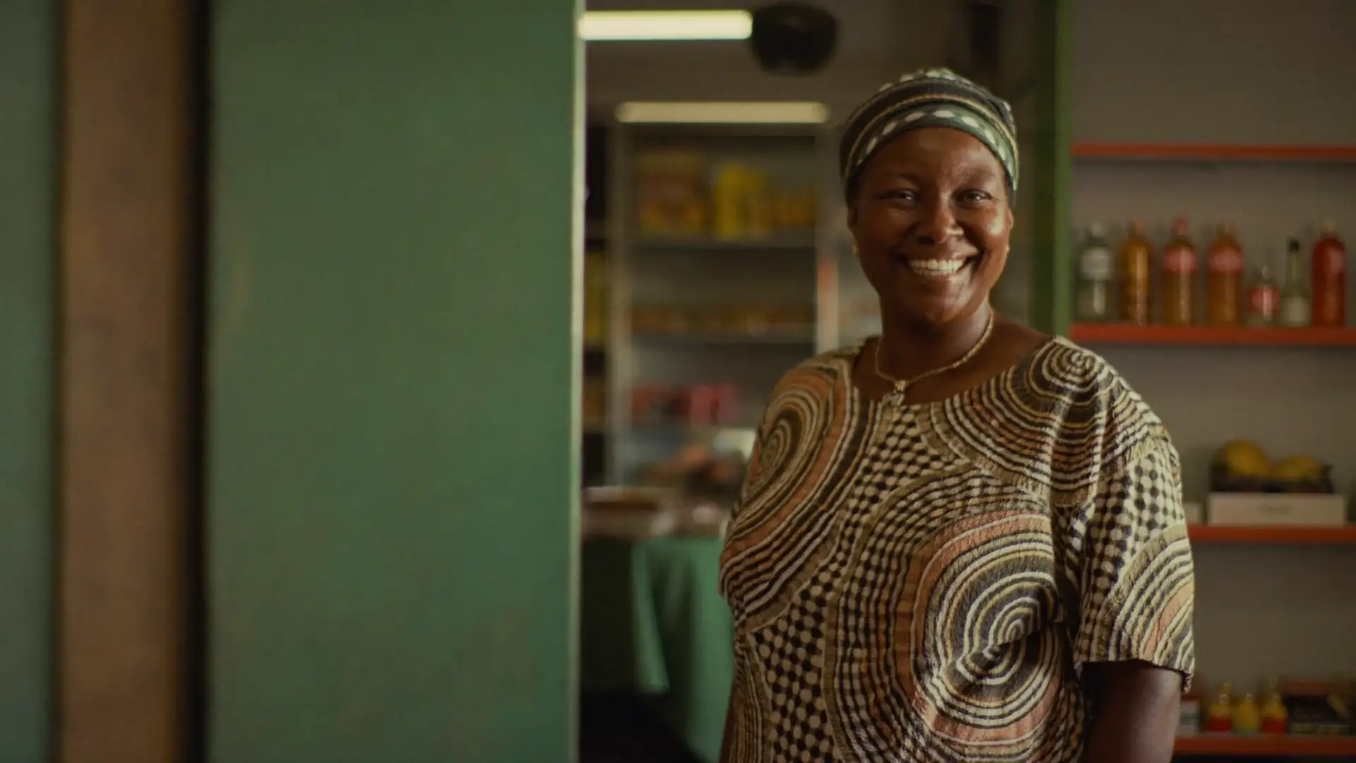 A Zimbabwean woman shop owner smiling in her shop, a Creditree client